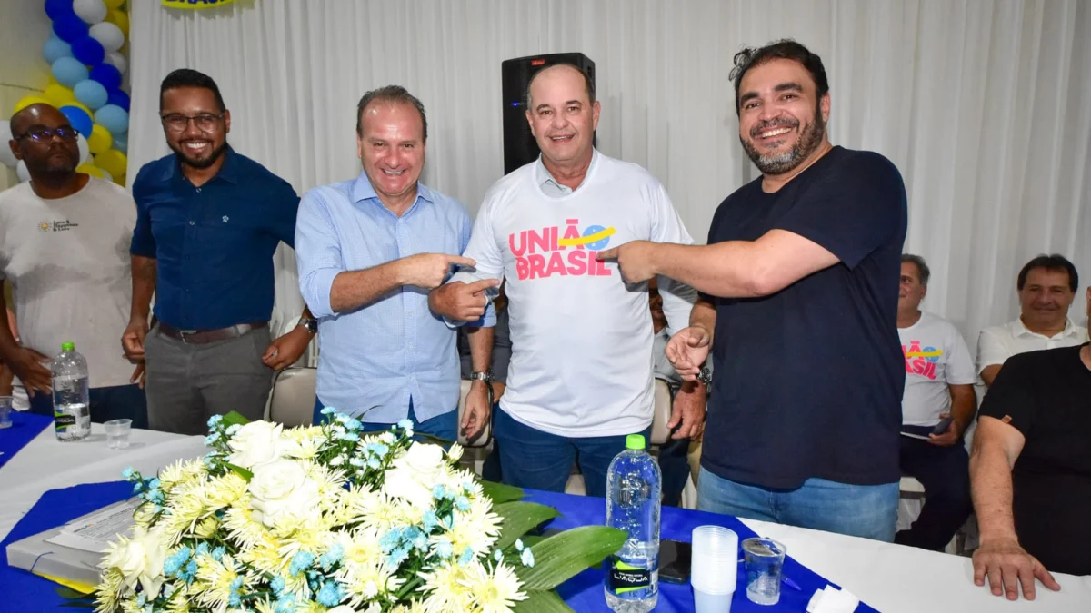 O secretário-geral do União Brasil, Bilac Pinto, e o presidente estadual da legenda, deputado federal Marcelo Freitas, apontam para a marca
