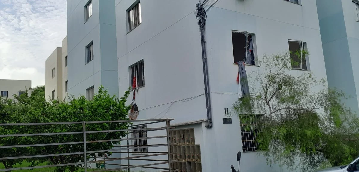 Fachada do prédio onde se vê as janelas do apartamento quebradas pelos tiros e pela bomba